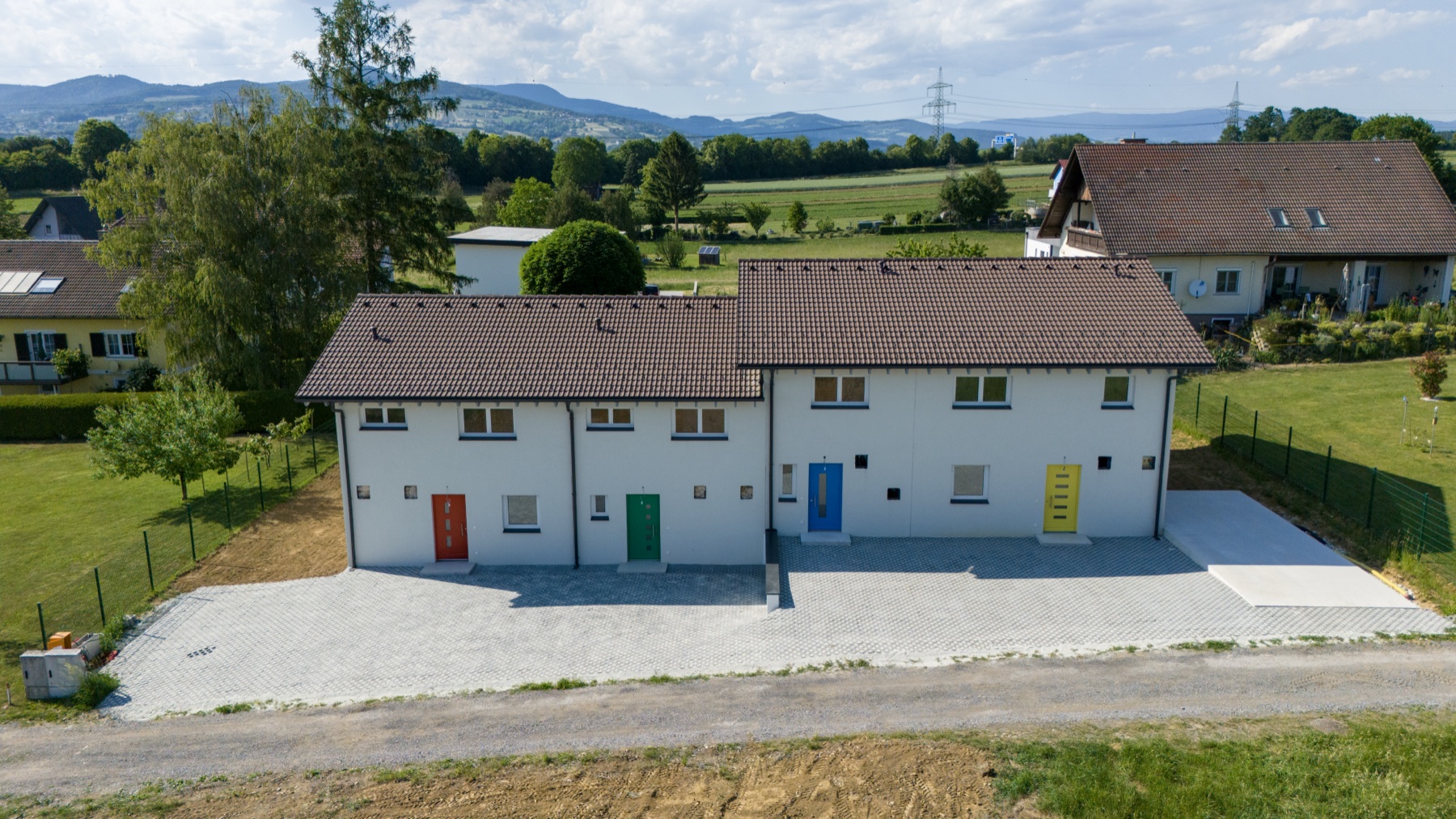 Luftaufnahme des GartenQuartetts mit vier Reihenhäusern und farblich markierten Eingängen